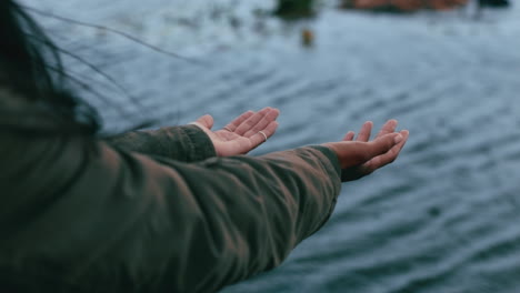 unknown woman catching raindrops in her hands