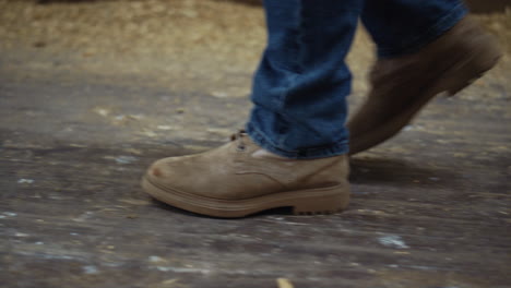 farmer legs walking cowshed building closeup. livestock owner inspecting barn