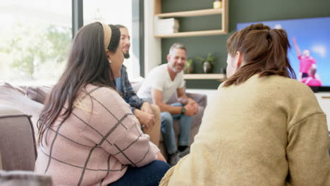 Happy-diverse-male-and-female-friends-watching-sport-on-tv-at-home-drinking-beers,-copy-space