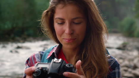 excursionista usando una cámara fotográfica durante la caminata. fotógrafo mirando imágenes en la cámara