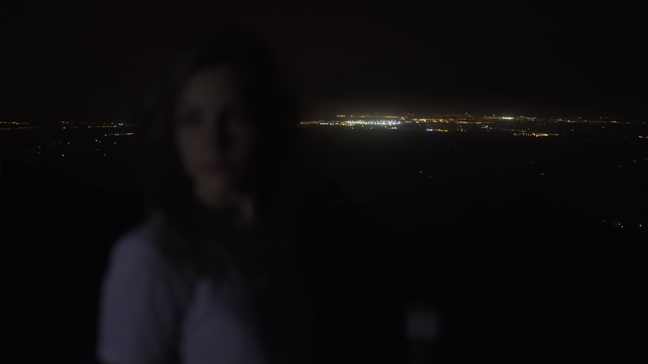 마요르카, 스페인에서 밤에 도시의 높은 산 보고 불빛에 여자