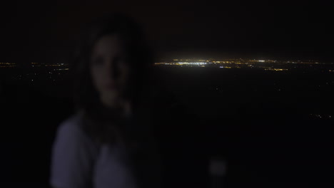 mujer en alta montaña viendo luces de pueblos por la noche en mallorca, españa