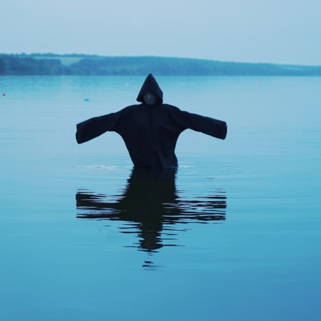 evil witch in a black hood in the river