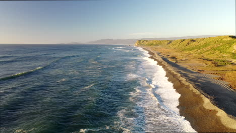 forward dolly nature beach chiloé island chonchi chile sun down stone rock wave green hill
