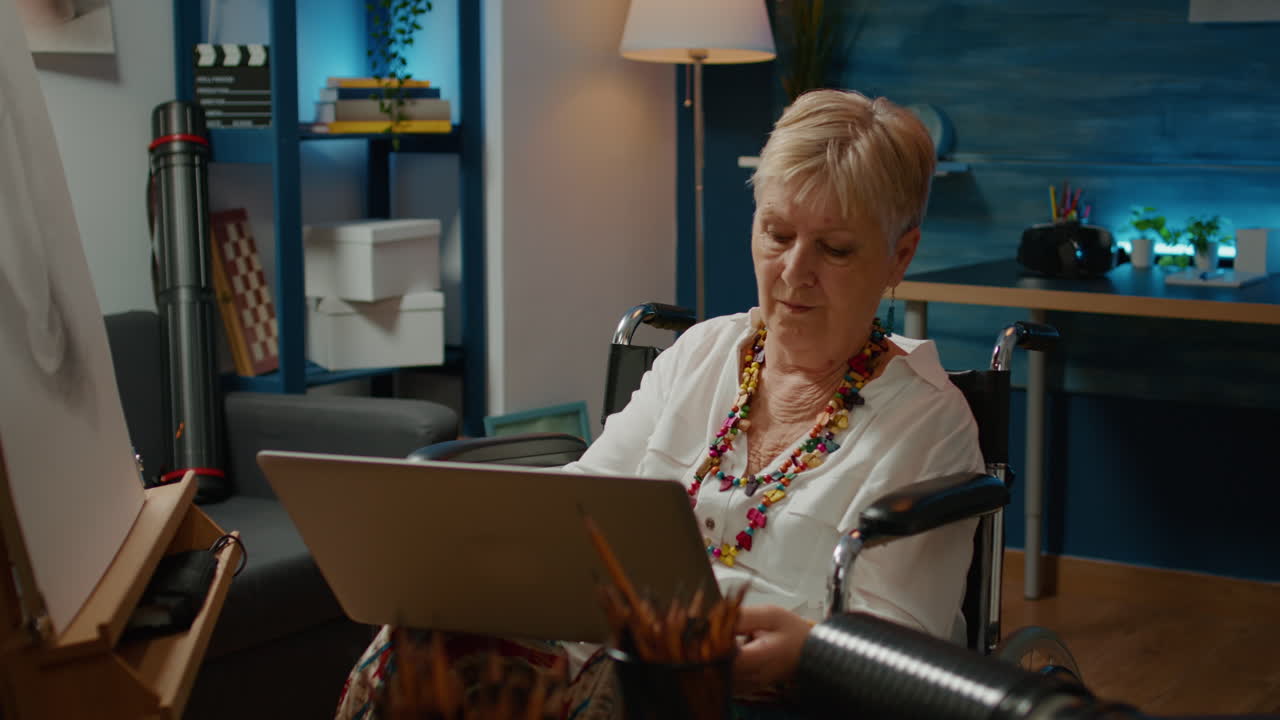 Senior woman with chronic impairment using laptop to draw vase sketch