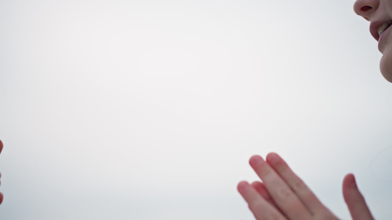 clapping hands on misty shoreline, training partner exchange warm palms in yellow jackets closeup of skin and palm contact, supportive gesture after practice, soft sea mist and muted horizon, slow