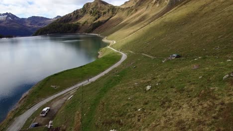 Luftaufnahme:-Autos-Fahren-Mit-Einem-Geländewagen-In-Der-Schweizer-Berglandschaft-Eine-Schwierige-Steile-Bergstraße-Hinunter,-Das-Auto-Bleibt-Auf-Einer-Schwierigen-Straße-Stecken