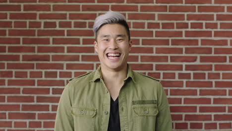 portrait of handsome young asian man laughing cheerful at camera