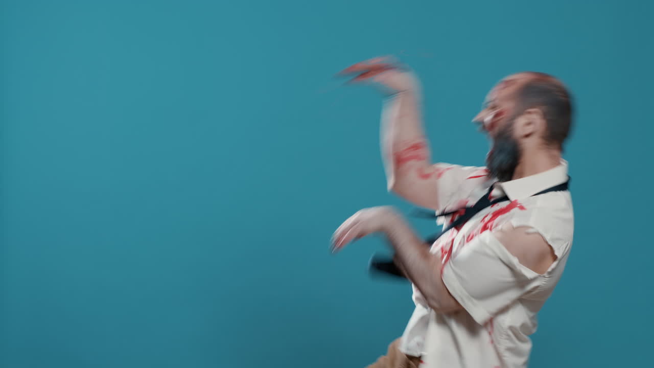 Evil spooky looking zombie doing a funny dance on blue background