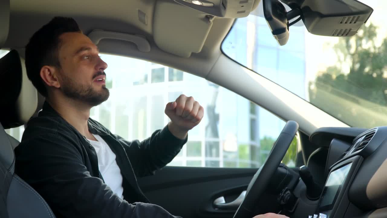 hombre barbudo mira en el espejo retrovisor en el coche cerca del centro de negocios. negocio de automóviles, tecnología y concepto de personas