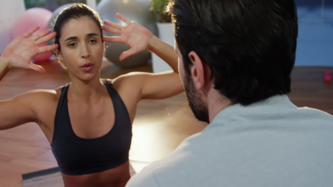 fisioterapeuta asistiendo a una paciente mientras hace ejercicio