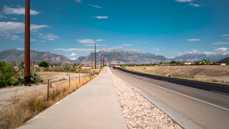 Traffic-flowing-along-a-highway-on-a-summer-day-with-the-Rocky-Mountains-in-the-background---static-time-lapse