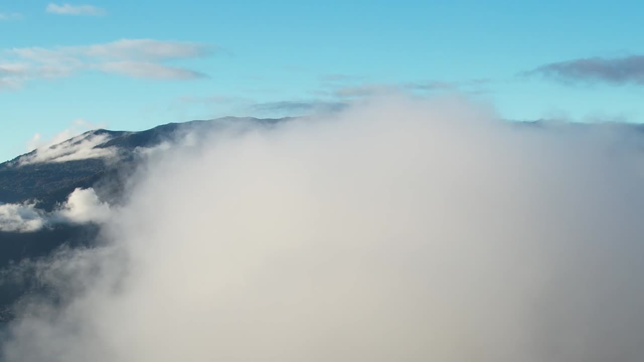 Clouds enveloping the Alps captured from a drone in Italy