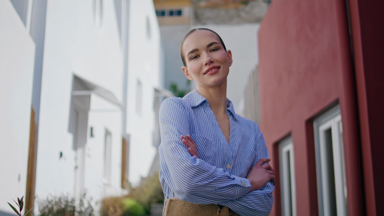 Portrait smiling woman posing at mediterranean architecture. Lady looking camera