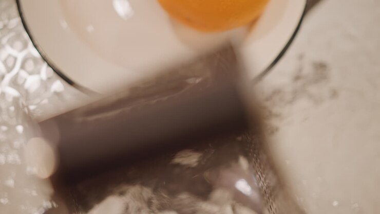 Chef demonstrates citrus zesting technique. Closeup of grater motion over bowl showing beautiful zesting process. Chef skillfully demonstrates how to grate orange peel over warm porcelain bowl