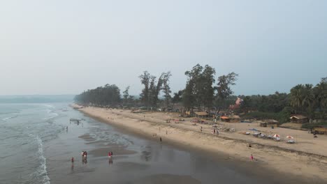 drone fly above people and palm trees on sandy beach