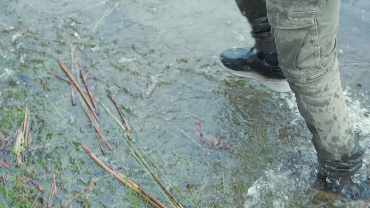 refugiados caminan por el río en europa, pies en cámara lenta