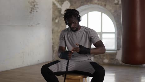 Confident-Boxer-Is-Wrapping-Hands-With-Black-Bandage