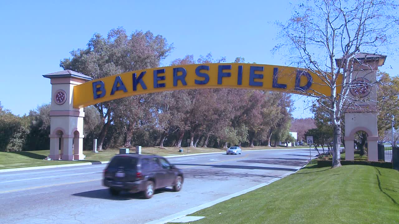 자동차는 도시로 통하는 전통적인 아치형 관문 아래 베이커즈필드 캘리포니아로 진입합니다.