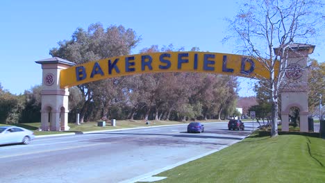 cars drive into bakersfield california under the traditional arched gateway to the city