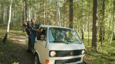 excited friends riding van with opened door