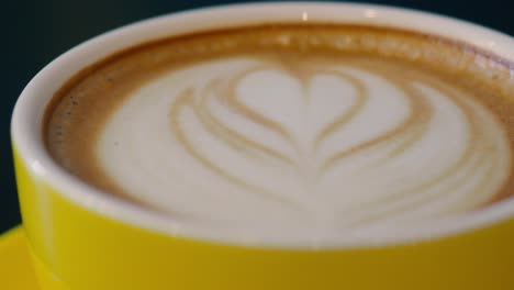 fresh coffee latte drink closeup in a yellow mug