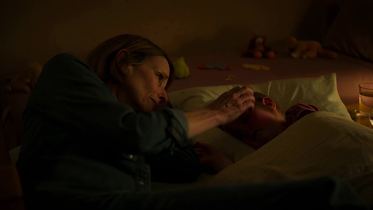 White Mother And Child Bedtime In Dim Bedroom With Lamp Mother Watches And Gently Tucks Sleeping Child,