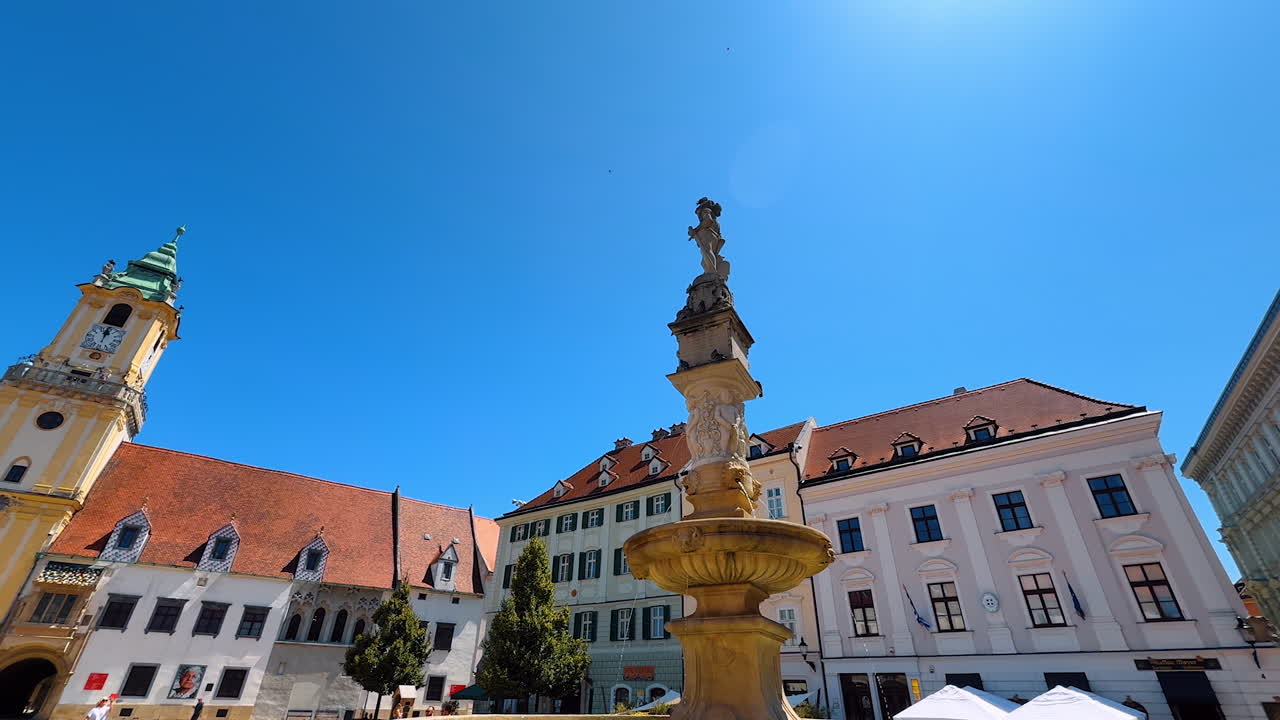 Fountain with statue decorating the square of the old town. Low angle view on the gorgeous architecture of Bratislava, Slovakia