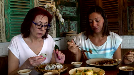 women eat and talk while sitting at a table in a vietnamese restaurant