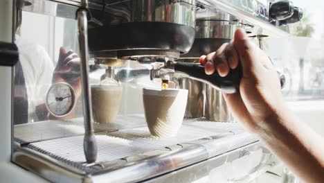 Close-up-of-african-american-male-barista-making-coffee-at-cafe