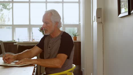 hombre mayor sentado en la mesa en la sala de estar 4k