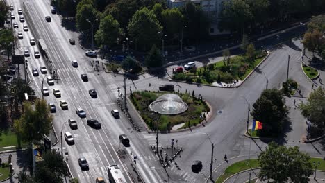 rotating aerial view over constantin brancoveanu square with traffic below and a fountain in the middle, bucharest, romania