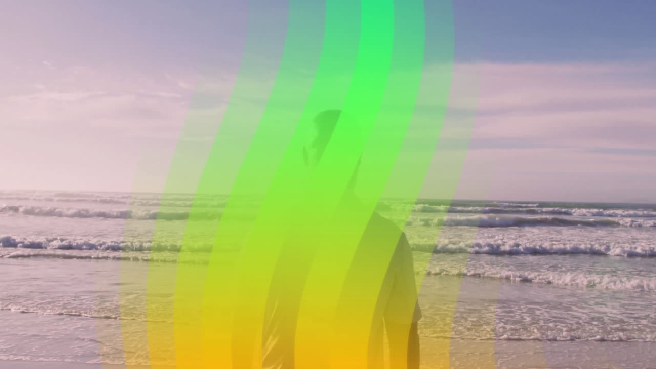 Colorful wave animation over person standing on beach with ocean waves