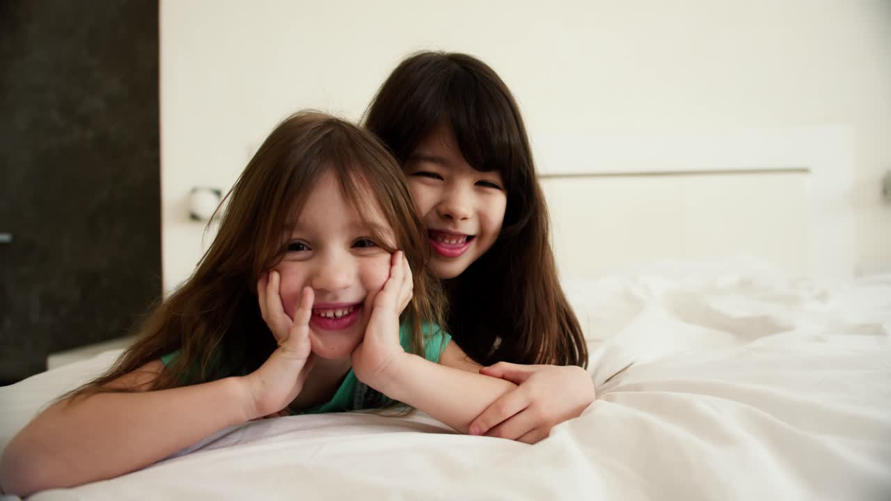 Two happy small kids in bedroom, smiling and looking to the camera