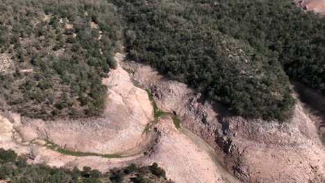 rough stone woodland topped ravine of the sau reservoir during drought season low water levels, catalonia, spain