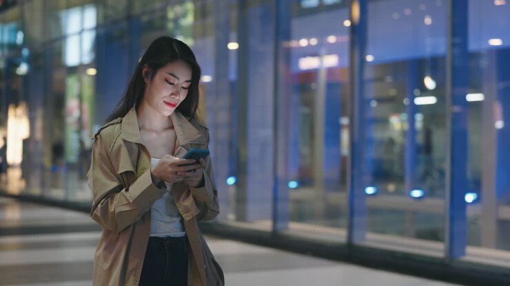 Woman using mobile phone at night in a city