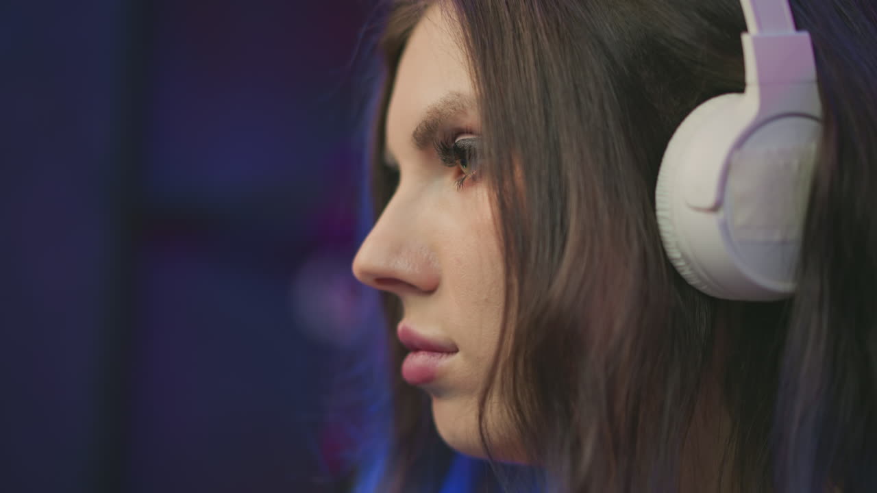 close up side profile of woman with long eyelashes wearing white headphones deeply focused with soft blurred background in ambient lighting creating calm and introspective atmosphere