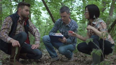 scientists discussing samples in a forest