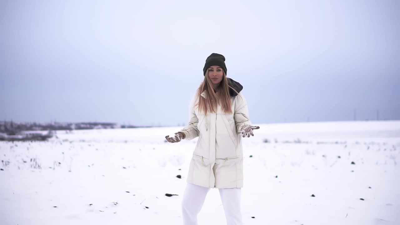 niña lanzando bolas de nieve a la cámara sonriendo feliz divirtiéndose al aire libre
