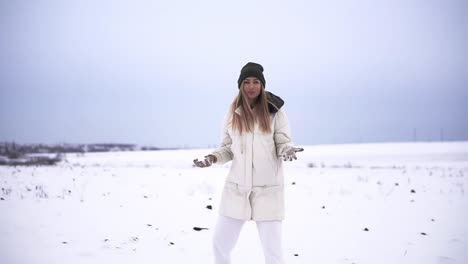 Girl-throwing-snowball-at-camera-smiling-happy-having-fun-outdoors