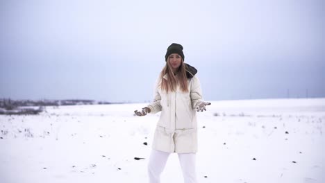 girl throwing snowball at camera smiling happy having fun outdoors