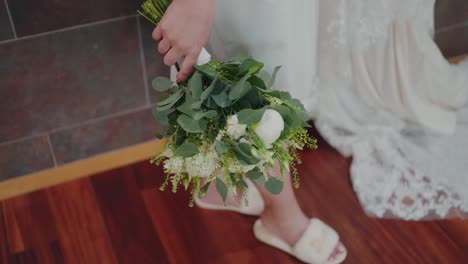 bride holding a lush wedding bouquet, details of white dress and sandals