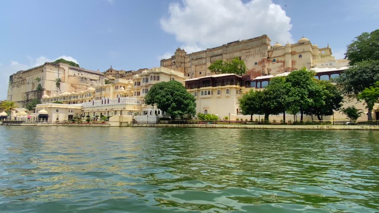 맑고 화창한 날 피콜라 호수 기슭에 있는 우다이푸르 도시 궁전을 지나 항해