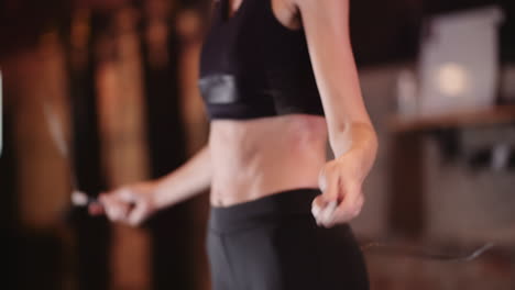 midsection of woman using skipping rope during fitness training