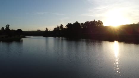 Vorwärtsbewegung-Mit-Drohne-In-Einem-Wunderschönen-See-Mit-Wasserspiegel-Bei-Sonnenuntergang