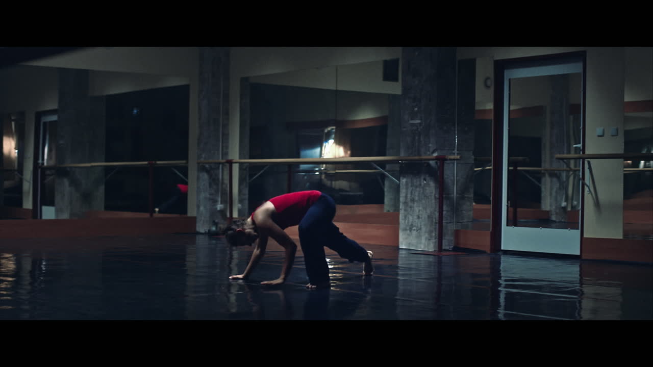 Una giovane donna pratica danza moderna e balletto in una stanza suggestiva piena di specchi