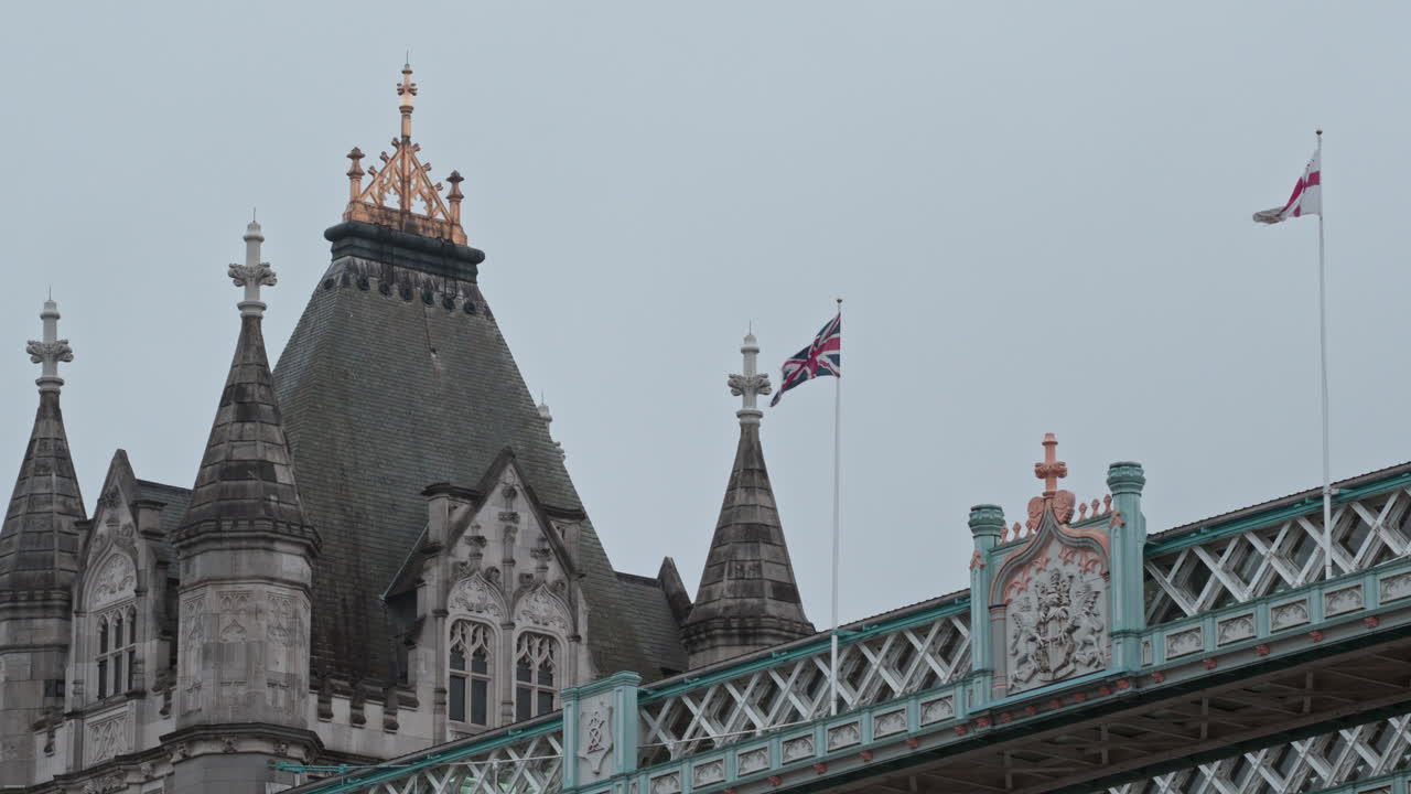 Tower Bridge med flagg på en overskyet dag, som viser ikonisk London-arkitektur.