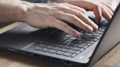 close-up. male hands are typing on a laptop keyboard. a man works on a computer