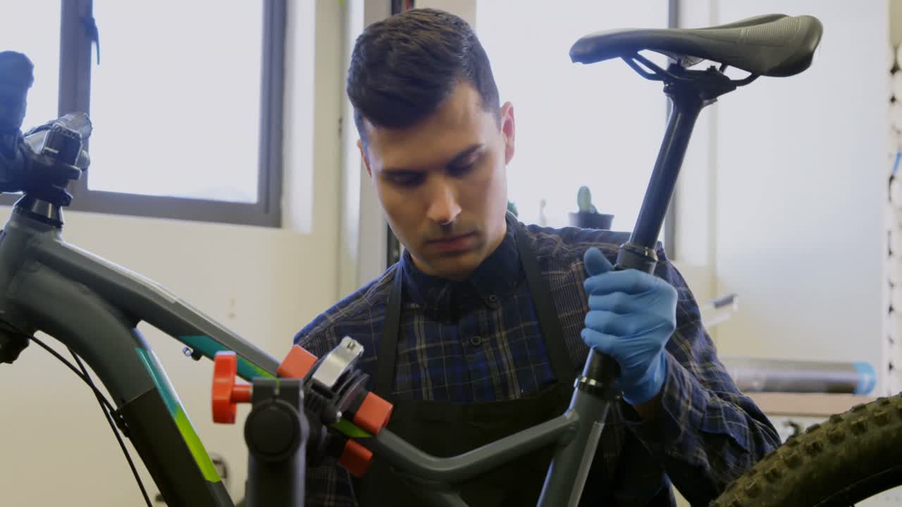 hombre reparando una bicicleta en el taller 4k