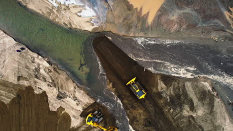 top view of heavy machines moving sediment after a river changed its course